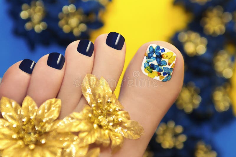 Blue pedicure with butterflies in white lacquer big toe with Golden flowers. Blue pedicure with butterflies in white lacquer big toe with Golden flowers.