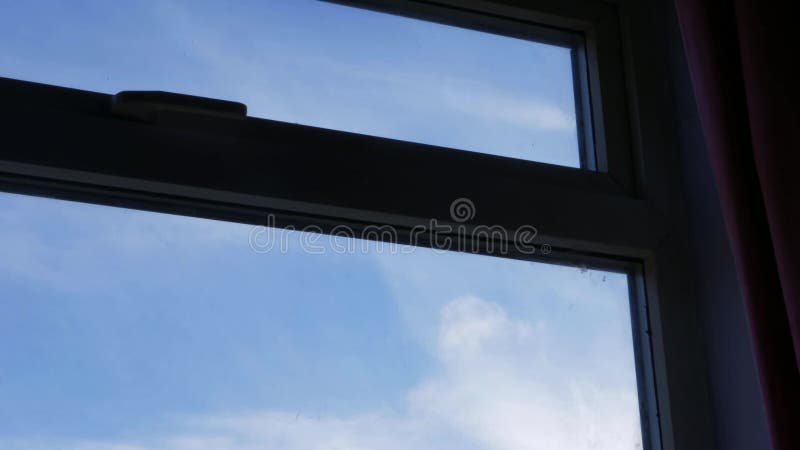 Période de nuages passant à travers le ciel bleu à travers la vue de la fenêtre clips vidéos