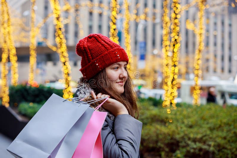 Pés do adolescente da forma que andam com os sacos de compras coloridos na rua de uma cidade, bokeh colorido das luzes imagem de stock Pés do adolescente da forma que andam com os sacos de compras coloridos na rua de uma cidade, bokeh colorido das luzes imagem de stock