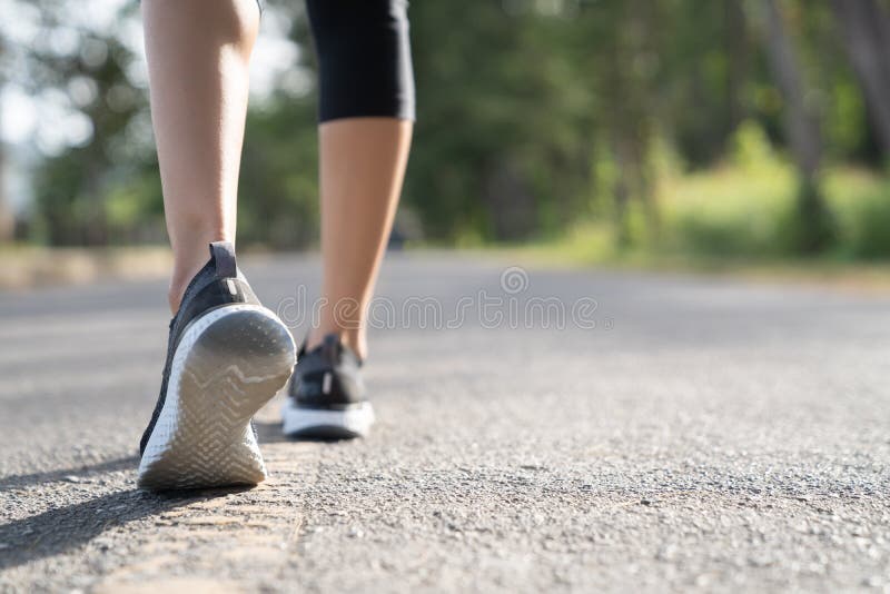 Pés do corredor que funcionam no close up da estrada na sapata Conceito do welness do exercício do movimento do nascer do sol da imagem de stock Pés do corredor que funcionam no close up da estrada na sapata Conceito do welness do exercício do movimento do nascer do sol da imagem de stock