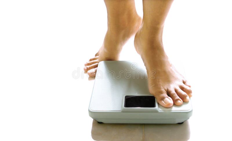 Pés femininos aproximadamente a estar em uma escala de peso.