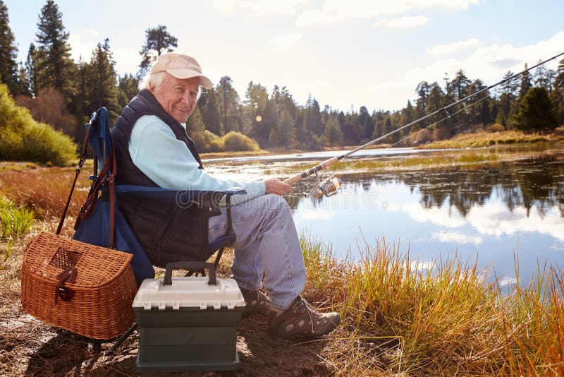 Pêche d'homme supérieur dans un lac, regardant à l'appareil-photo, la Californie photos libres de droits Pêche d'homme supérieur dans un lac, regardant à l'appareil-photo, la Californie photos libres de droits