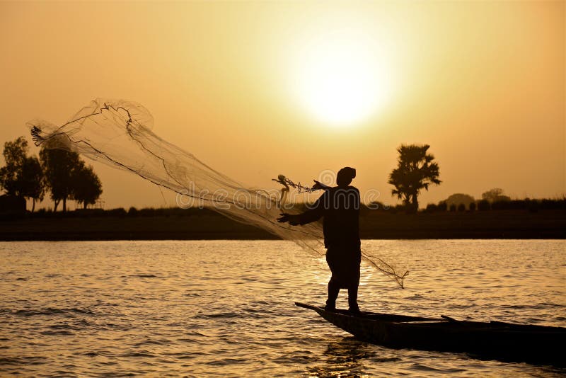 Fisherman throwing his net during sunset. Fisherman throwing his net during sunset