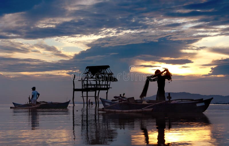 Pêcheurs asiatiques avec le coucher du soleil. image stock Pêcheurs asiatiques avec le coucher du soleil. image stock