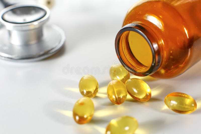 Píldoras coloreadas vertidas de una botella marrón Concepto MÉDICO imágenes de archivo libres de regalías