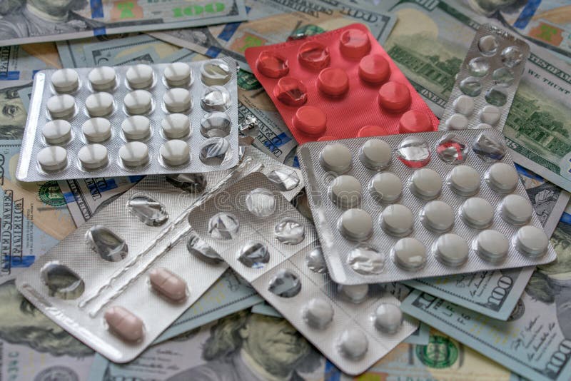 Píldoras en el dinero de 100 dólares Costos de la medicina Altos costes del concepto costoso de la medicación foto de archivo Píldoras en el dinero de 100 dólares Costos de la medicina Altos costes del concepto costoso de la medicación foto de archivo