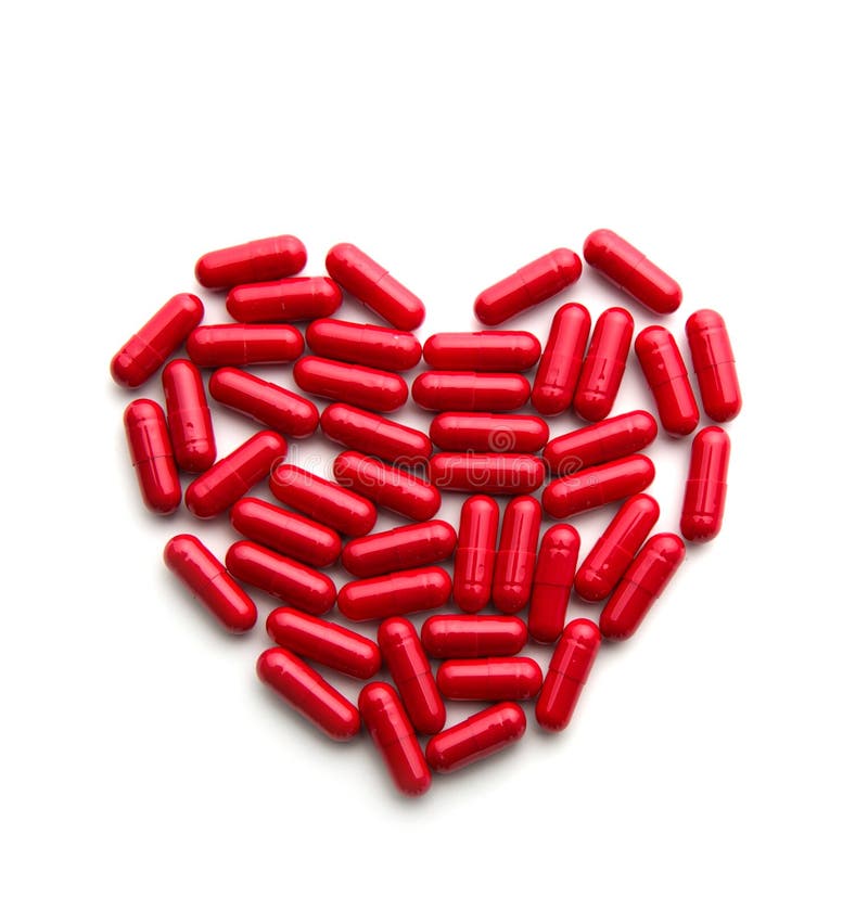 Píldoras largas rojas en una forma del corazón imágenes de archivo libres de regalías Píldoras largas rojas en una forma del corazón imágenes de archivo libres de regalías