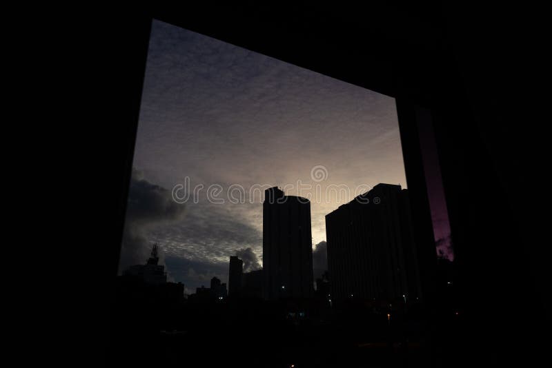 Pôr do sol dramático e bonito com nuvens coloridas e parte de edifícios residenciais na silhueta imagens de stock