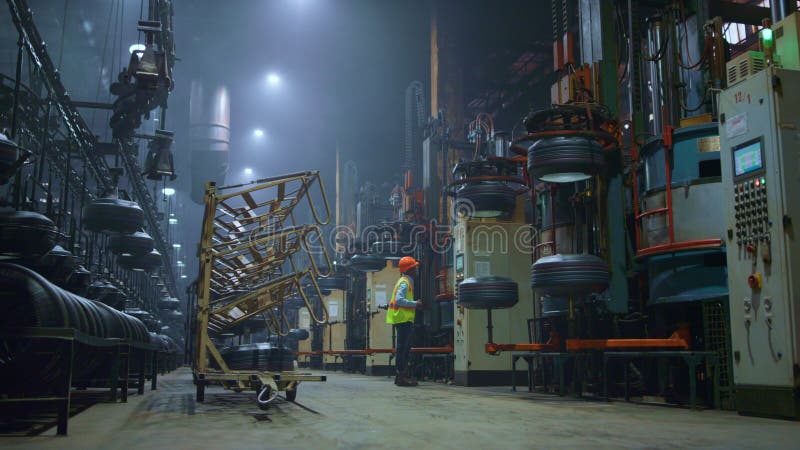 Păr negru profesionist în picioare în apropierea unei mari construcții moderne de metal la depozitare. stock image
