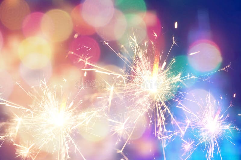 Płonący bożego narodzenia sparkler na kolorowym lekkim tle zdjęcia royalty free Płonący bożego narodzenia sparkler na kolorowym lekkim tle zdjęcia royalty free