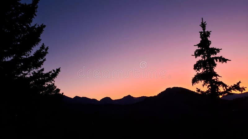 Płonący zachód słońca z sylwetką górską i drzewną fotografia royalty free Płonący zachód słońca z sylwetką górską i drzewną fotografia royalty free