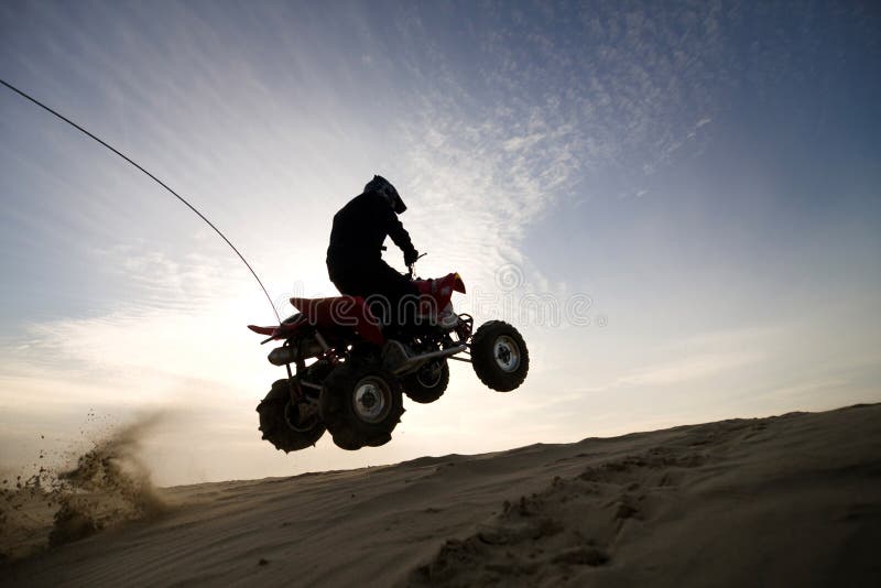 Quad il cavaliere che salta nel tramonto immagini stock libere da diritti Quad il cavaliere che salta nel tramonto immagini stock libere da diritti