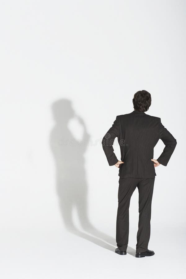 Quadris de With Hands On do homem de negócios que discutem sua própria sombra imagens de stock royalty free Quadris de With Hands On do homem de negócios que discutem sua própria sombra imagens de stock royalty free