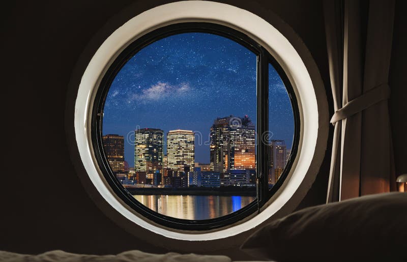 Quadro de janela redondo no quarto na noite com opinião da cidade