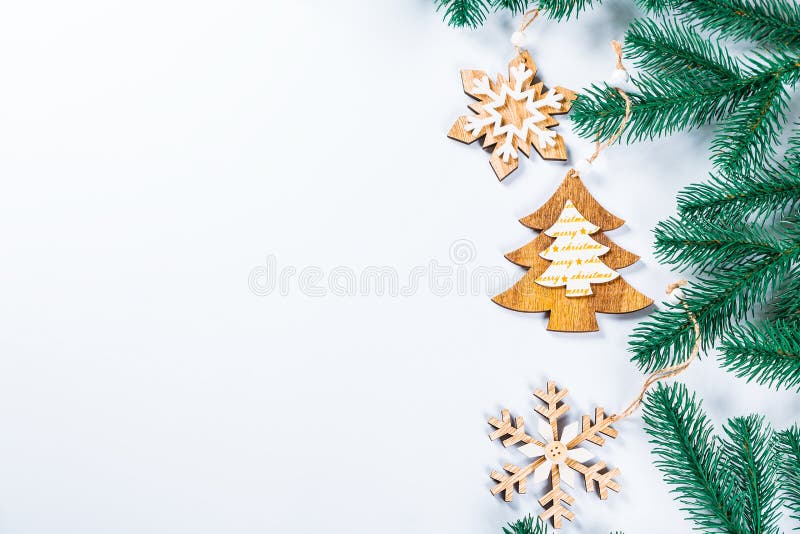 Quadro do Natal com os ramos da árvore de Natal e das decorações de madeira no fundo branco Composição simples w do Natal imagem de stock Quadro do Natal com os ramos da árvore de Natal e das decorações de madeira no fundo branco Composição simples w do Natal imagem de stock