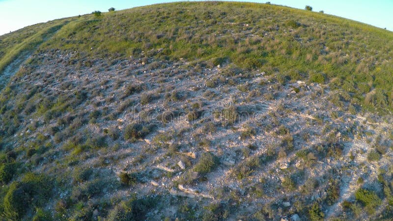 Quadrocopter летая вниз с известковых скал стрельбы холма оставаясь на поверхности