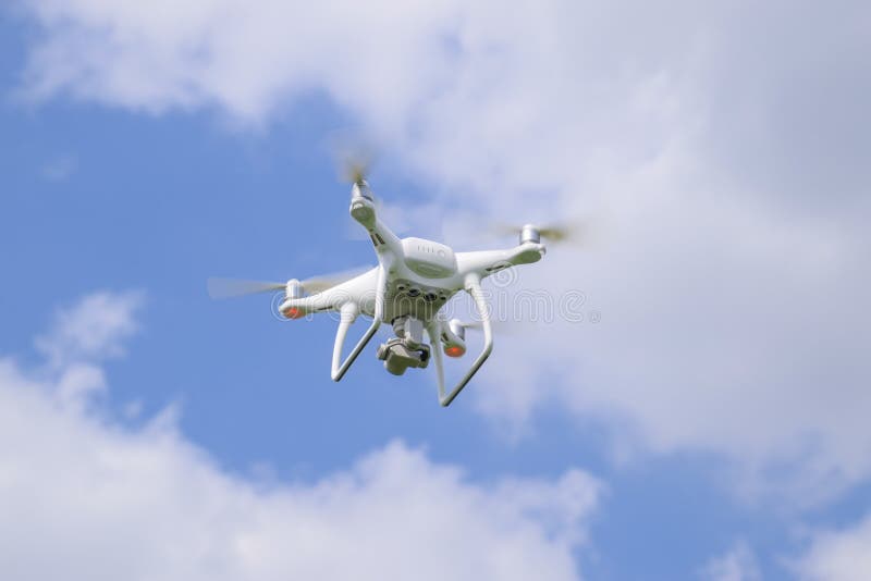 Russia, Poltavskaya village - May 1, 2016: Flying white quadrocopters DJI Phantom 4 over a field of wheat. Flying gadget for video. Russia, Poltavskaya village - May 1, 2016: Flying white quadrocopters DJI Phantom 4 over a field of wheat. Flying gadget for video.