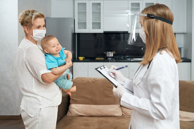 Qualified Doctor In Mask Examining Toddler At Home Stock Photo Image