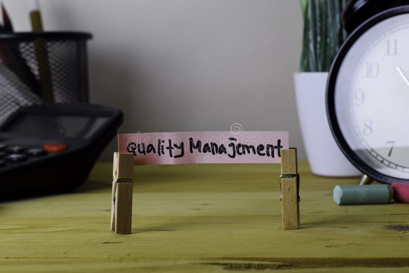 Qualità Manajement Scrittura sulle note appiccicose in mollette sulla scrivania di legno immagini stock libere da diritti Qualità Manajement Scrittura sulle note appiccicose in mollette sulla scrivania di legno immagini stock libere da diritti