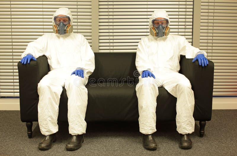 Quarantine. People in professiona protective clothing, mask and gloves, sitting on the sofa  and waiting for the end. Quarantine. People in professiona protective clothing, mask and gloves, sitting on the sofa  and waiting for the end