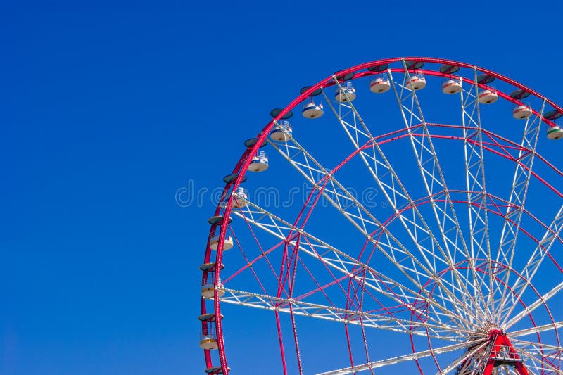 Quarter Ferris wheels with deep blue sky in the background