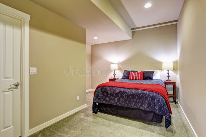 Quarto de convidado do porão com a cama azul e vermelha imagens de stock Quarto de convidado do porão com a cama azul e vermelha imagens de stock