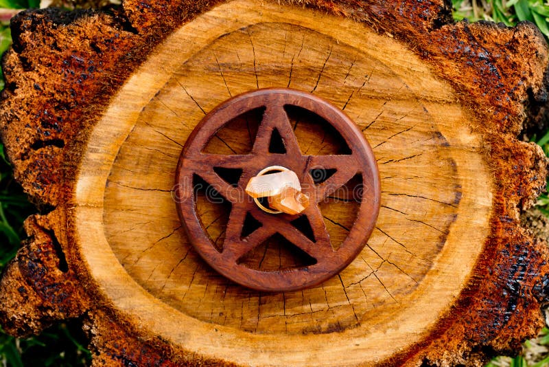 Quartz crystal in centre of brown wooden pentacle - pentagram on cut timber tree log. Quartz crystal in centre of brown wooden pentacle - pentagram on cut timber tree log