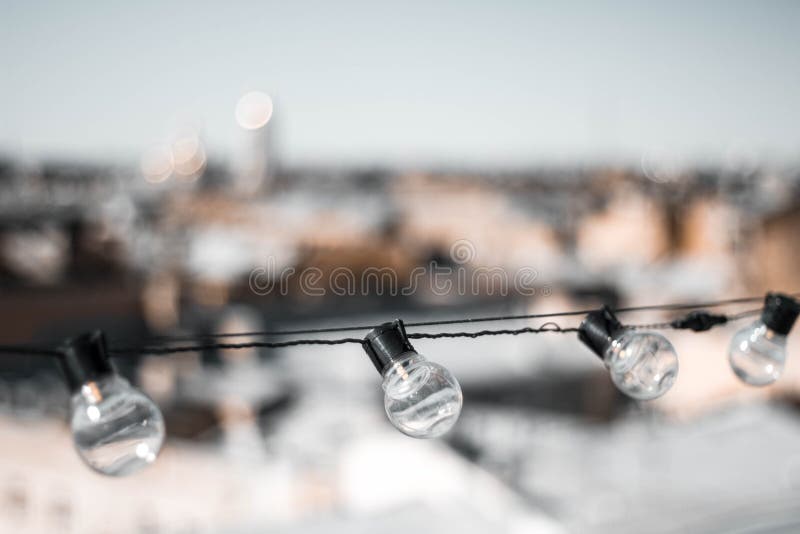 Quatre ampoules en verre contre les toits des maisons et du ciel L'ampoule sur le dessus La vue ? partir du dessus Fin vers le ha photos stock Quatre ampoules en verre contre les toits des maisons et du ciel L'ampoule sur le dessus La vue ? partir du dessus Fin vers le ha photos stock