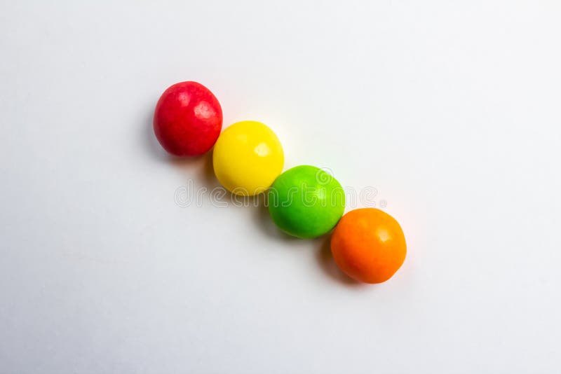 Quatre bonbons multicolores sur fond blanc