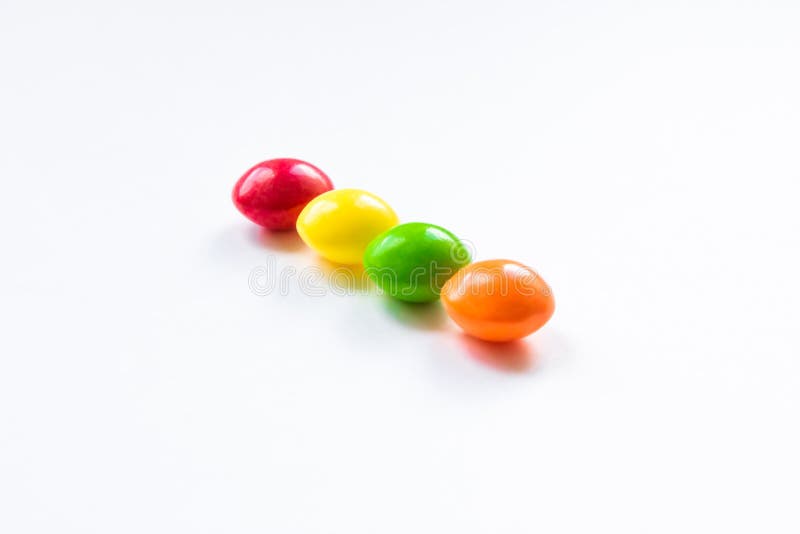 Quatre bonbons multicolores sur fond blanc
