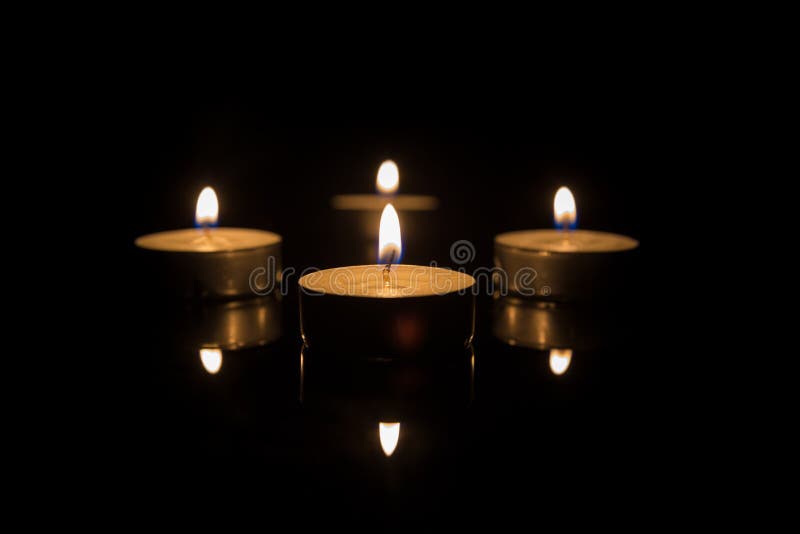 Quatre bougies de thé avec la réflexion sur le noir photo libre de droits Quatre bougies de thé avec la réflexion sur le noir photo libre de droits