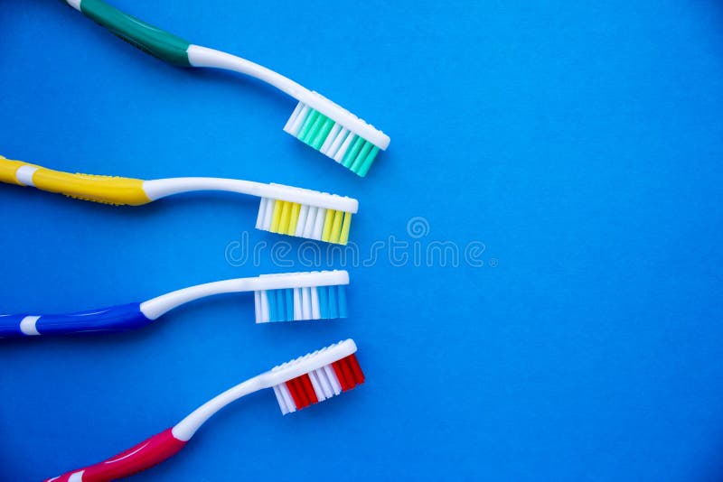 Quatre brosses à dents multicolores sur fond bleu