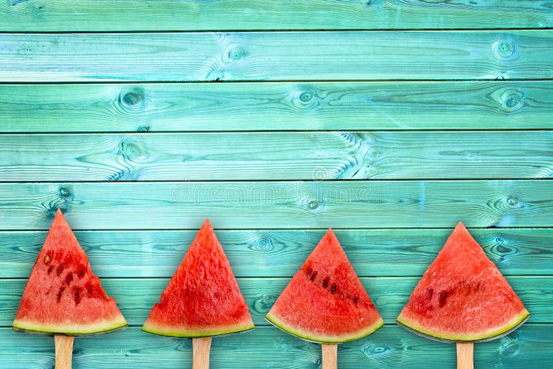 Quatre glaces à l'eau de tranche de pastèque sur le fond en bois bleu avec l'espace de copie, concept de fruit d'été photos stock