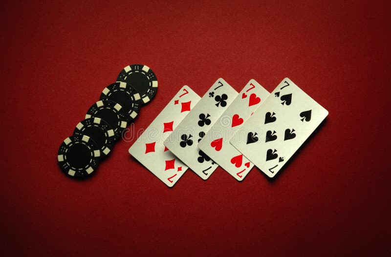 Four sevens in a poker game is a winning combination of four of a kind or quads on a red table in a club. Four sevens in a poker game is a winning combination of four of a kind or quads on a red table in a club.