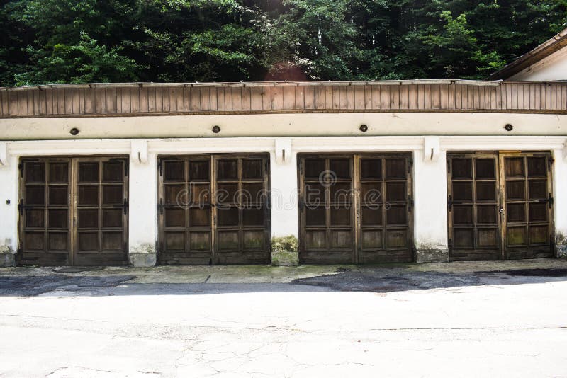 Quatro portas velhas da garagem na construção antiga do grunge na cidade abandonada foto de stock Quatro portas velhas da garagem na construção antiga do grunge na cidade abandonada foto de stock