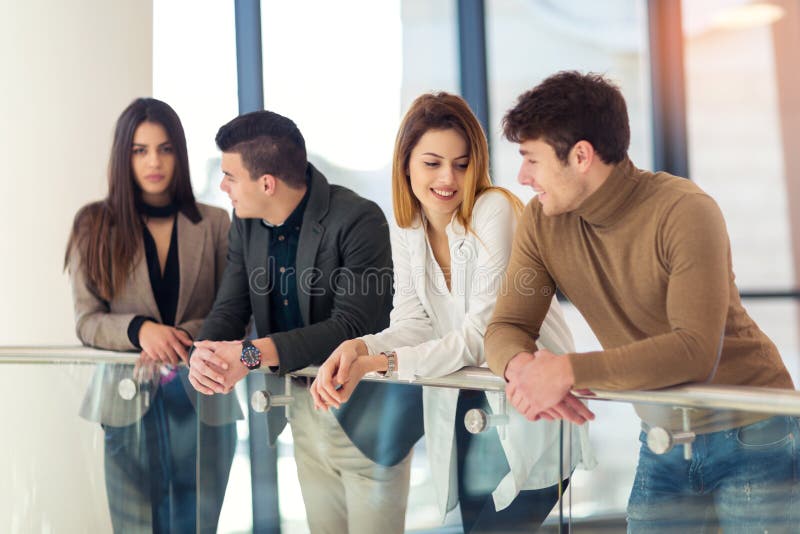 Quattro colleghi che parlano nell'edificio per uffici del corridoio immagini stock libere da diritti Quattro colleghi che parlano nell'edificio per uffici del corridoio immagini stock libere da diritti
