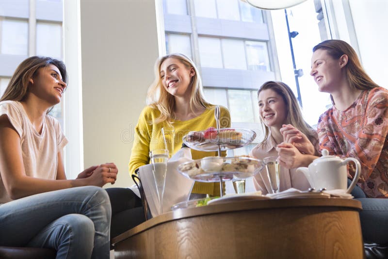 Quattro donne che mangiano il tè di pomeriggio immagine stock Quattro donne che mangiano il tè di pomeriggio immagine stock