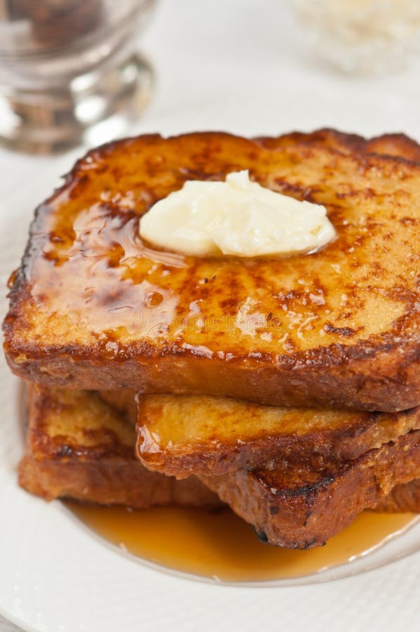 Quattro fette di pane tostato francese di recente cotto e casalingo con burro e di sciroppo d'acero immagini stock libere da diritti Quattro fette di pane tostato francese di recente cotto e casalingo con burro e di sciroppo d'acero immagini stock libere da diritti