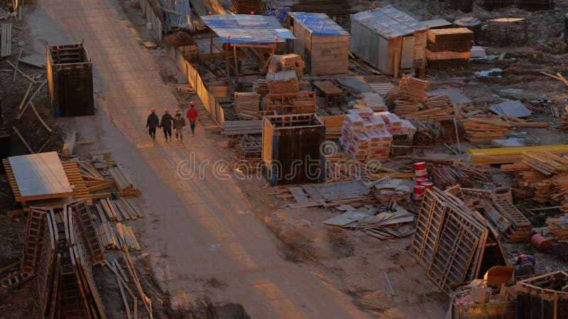Quattro lavoratori stanno camminando lungo una strada polverosa al cantiere