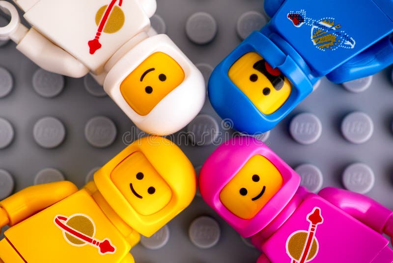 Quattro minifigures dell'astronauta di Lego sul fondo grigio della piastra di base fotografia stock libera da diritti Quattro minifigures dell'astronauta di Lego sul fondo grigio della piastra di base fotografia stock libera da diritti