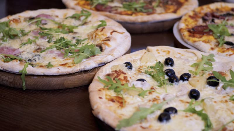 Quattro pizze su piastre di legno si trovano su un tavolo in un bar. chiusura. rallentamento