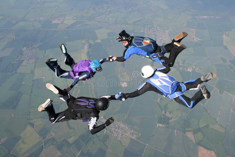 Quattro skydivers che tengono le mani immagini stock Quattro skydivers che tengono le mani immagini stock