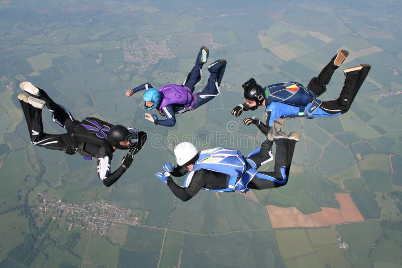 Quattro skydivers nella caduta libera fotografie stock Quattro skydivers nella caduta libera fotografie stock