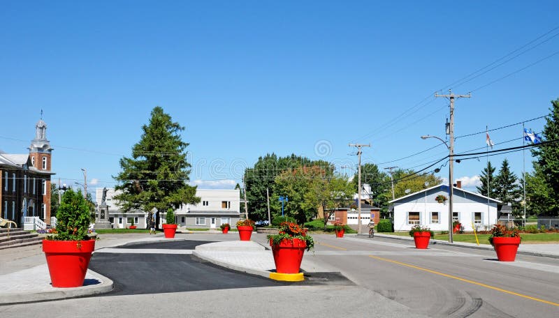 Quebec; Canada- june 25 2018 : main street in Metabetchouan. Quebec; Canada- june 25 2018 : red flowerpots in the main street in Metabetchouan stock photo Quebec; Canada- june 25 2018 : main street in Metabetchouan. Quebec; Canada- june 25 2018 : red flowerpots in the main street in Metabetchouan stock photo