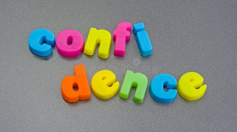 A macro concept image of breaking a confidence using colorful lower case letters isolated on a plain background. The word confidence is split in the middle a symbol of disclosing a secret. A macro concept image of breaking a confidence using colorful lower case letters isolated on a plain background. The word confidence is split in the middle a symbol of disclosing a secret.