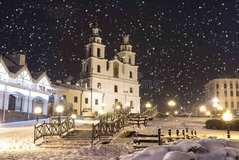 Snowfall in Minsk at winter night, Belarus. New Year and Christmas time in Minsk city. Cityscape of snowy Minsk. Cathedral of the Holy Spirit. Snowfall in Minsk at winter night, Belarus. New Year and Christmas time in Minsk city. Cityscape of snowy Minsk. Cathedral of the Holy Spirit