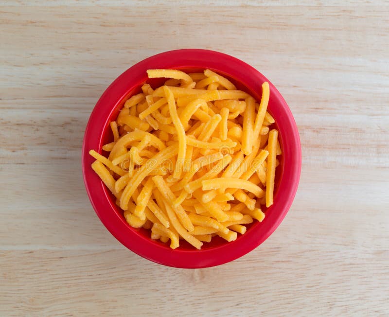 Queijo cheddar afiado Shredded na bacia vermelha imagens de stock royalty free Queijo cheddar afiado Shredded na bacia vermelha imagens de stock royalty free