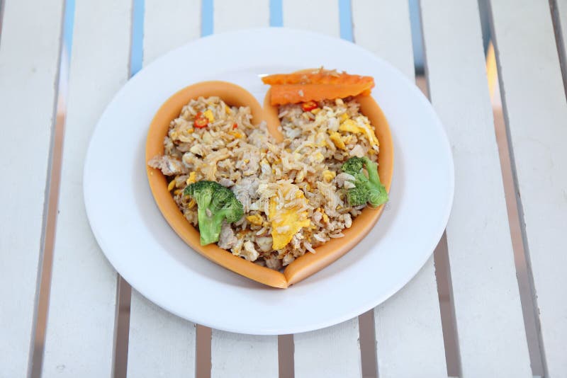 Queijo da salsicha no arroz fritado do envoltório do estilo do coração com a carne de porco coberta imagens de stock royalty free Queijo da salsicha no arroz fritado do envoltório do estilo do coração com a carne de porco coberta imagens de stock royalty free