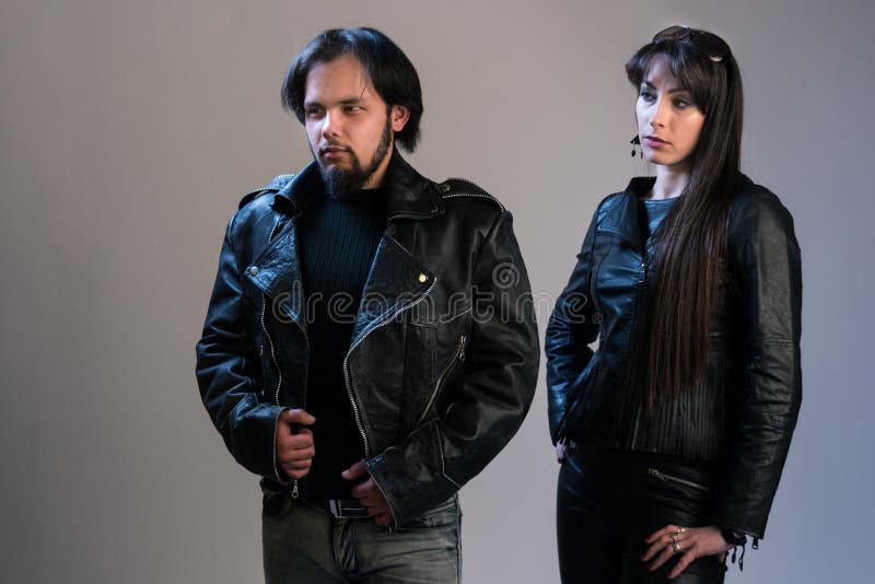 Quelques jeunes dans des vestes en cuir noires Un type et une fille dans le style de balancier ou de cycliste posant dans le stud image libre de droits Quelques jeunes dans des vestes en cuir noires Un type et une fille dans le style de balancier ou de cycliste posant dans le stud image libre de droits