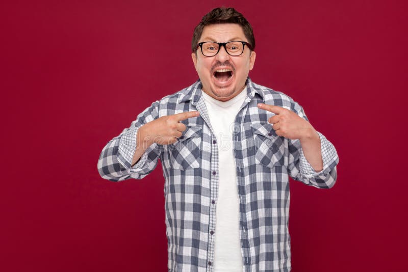 Quem? mim? O retrato do meio considerável surpreendido envelheceu o homem na posição quadriculado ocasional da camisa e dos monóc imagens de stock Quem? mim? O retrato do meio considerável surpreendido envelheceu o homem na posição quadriculado ocasional da camisa e dos monóc imagens de stock